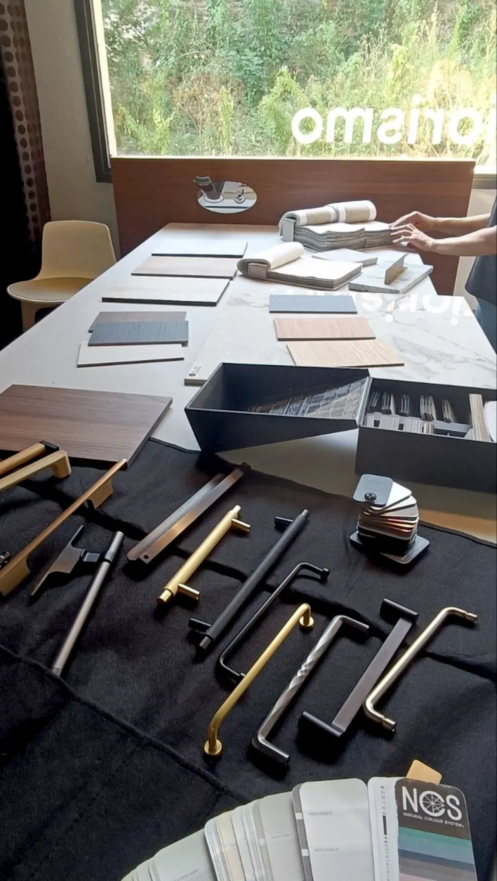 Mesa de trabajo con materiales, tiradores y muestras para un proyecto de interiorismo
