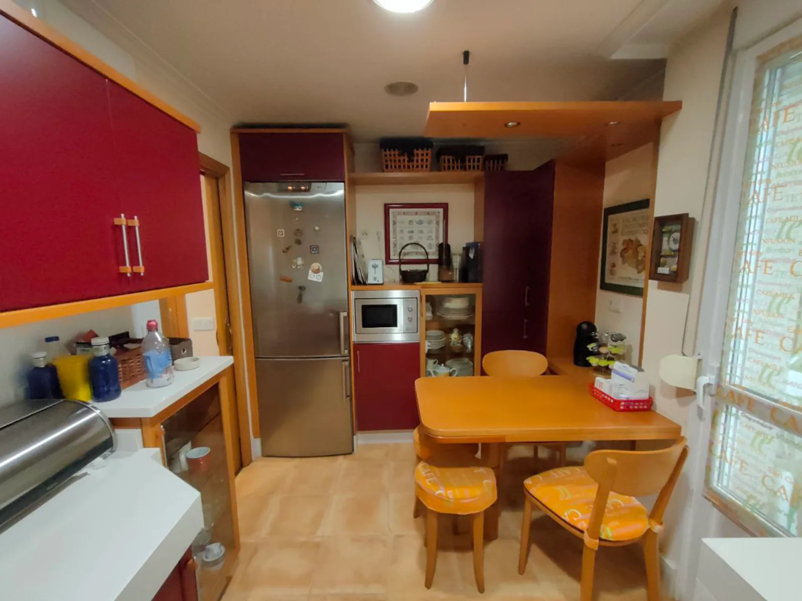 Cocina antes de la reforma con mesa estrecha, poca luz y distribución saturada.