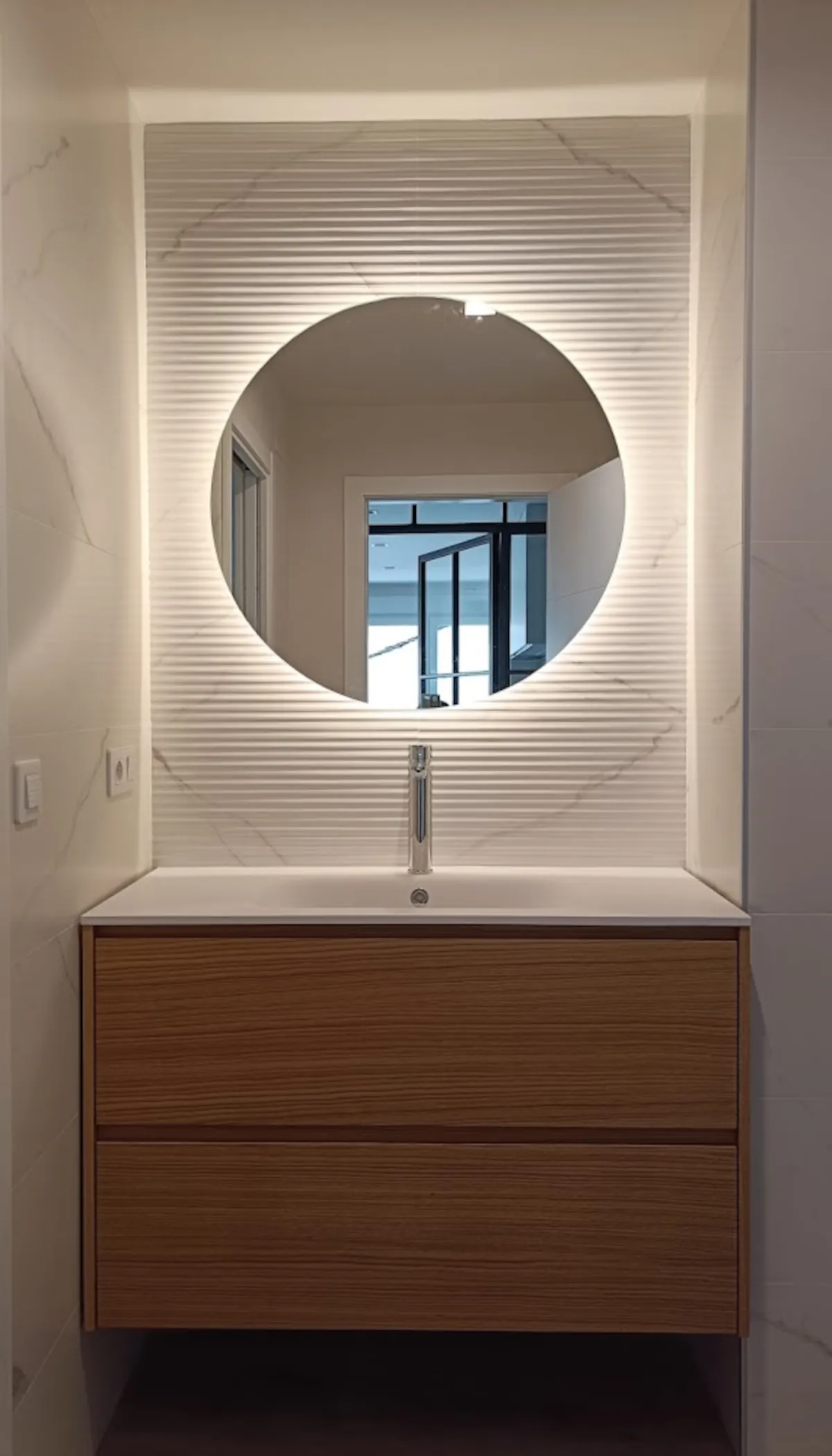 Mueble de lavabo, espejo e iluminación en el baño de la suite principal
