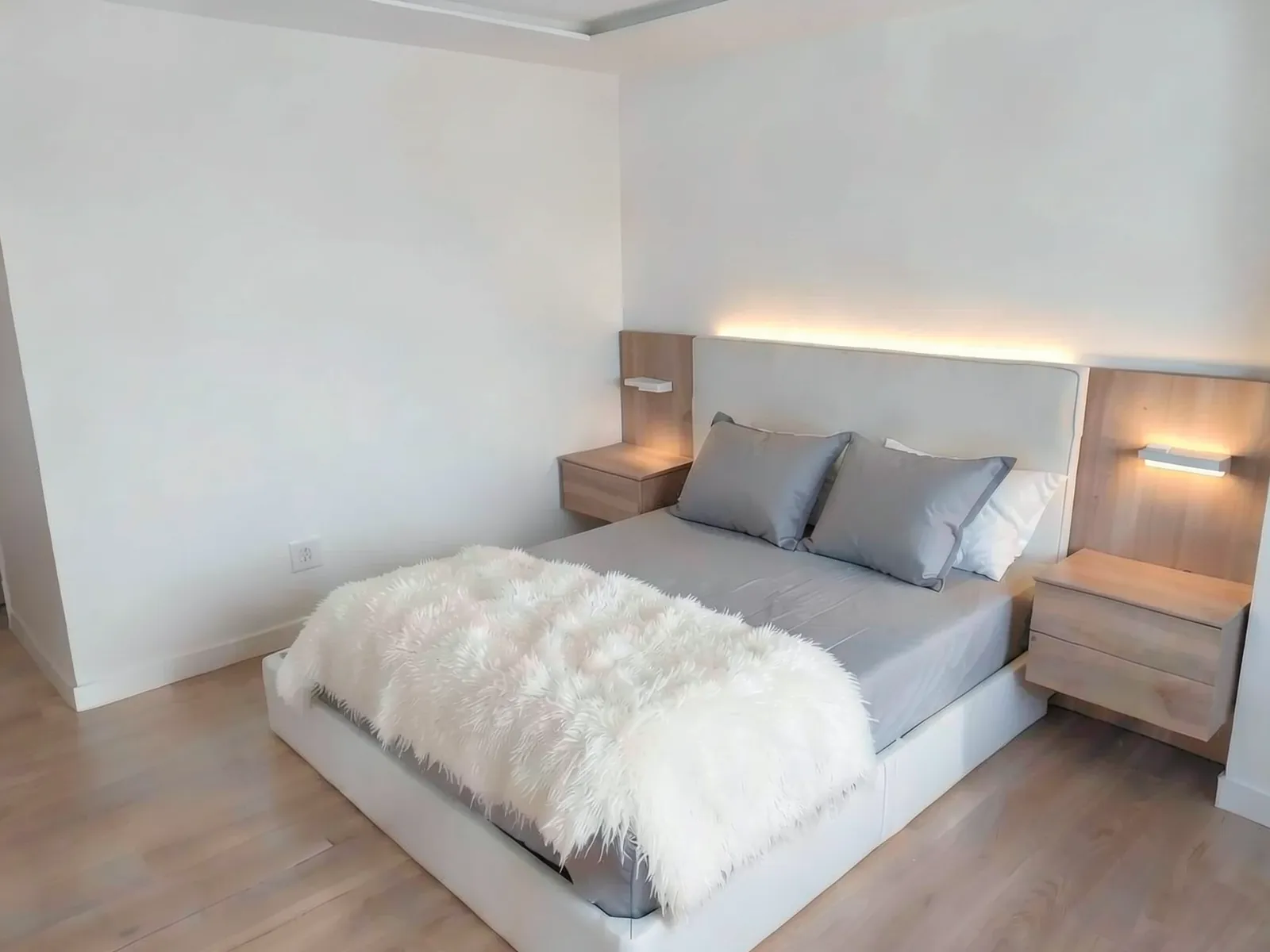Dormitorio principal con mobiliario e iluminación integrados tras la reforma